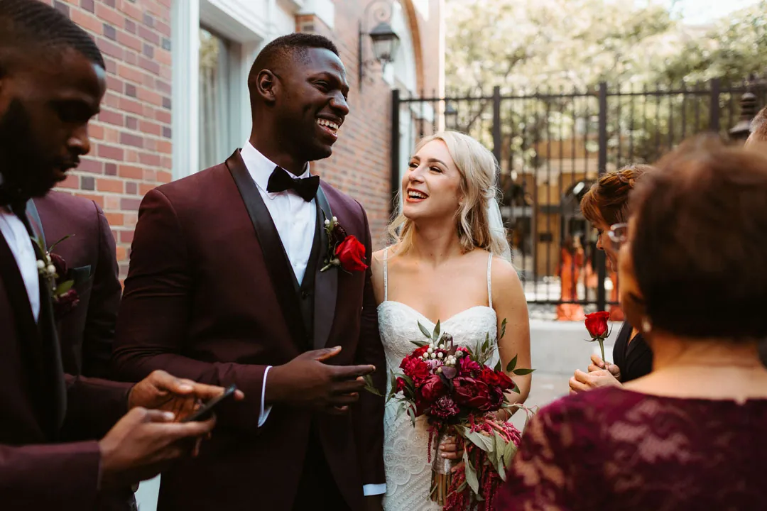 Bride and groom chatting with a guest