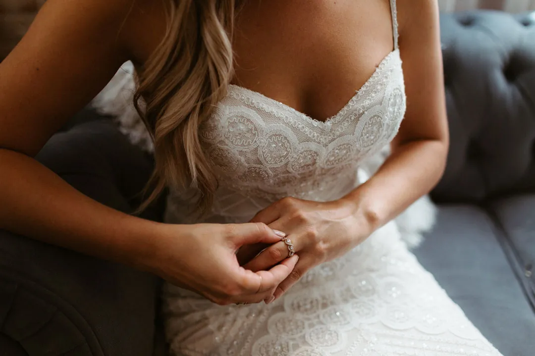 Bride adjusting jewelry while getting ready