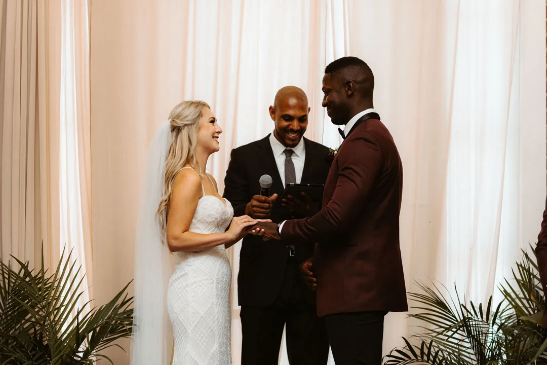 Bride and groom exchanging vows beside their officiant