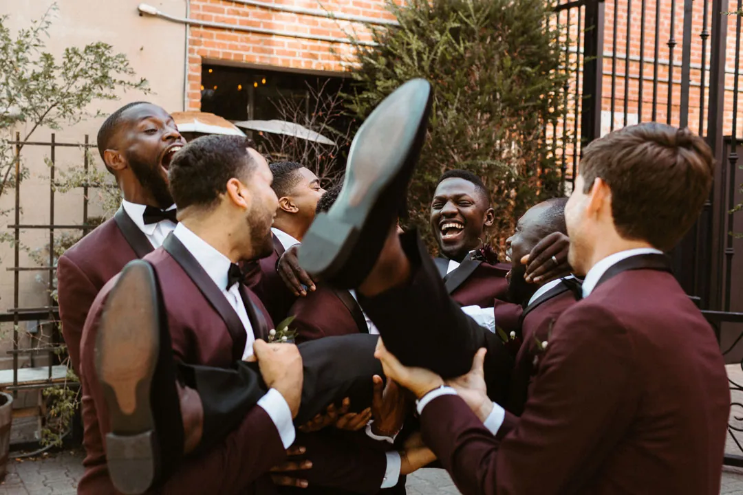 Groom celebrating with his attendants outdoors