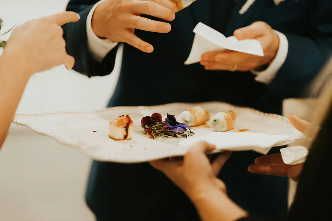 Guests share food from a plate at the reception.