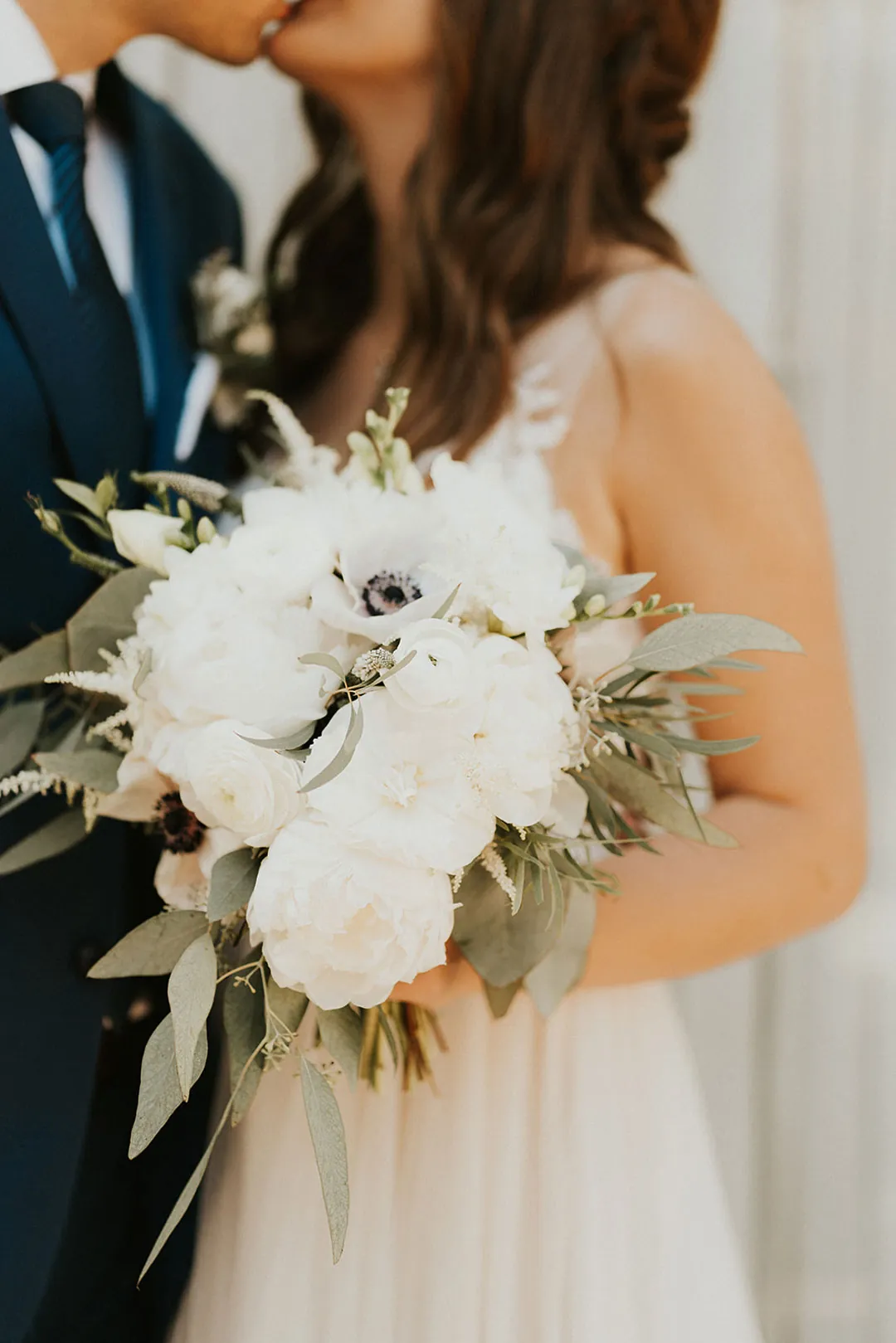 Bride holds a white floral bouquet.