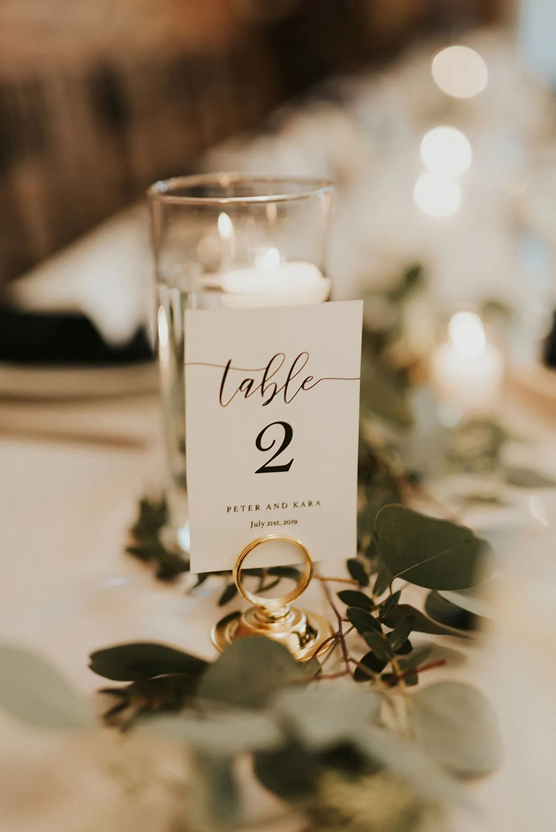Table number two beside greenery and glassware.
