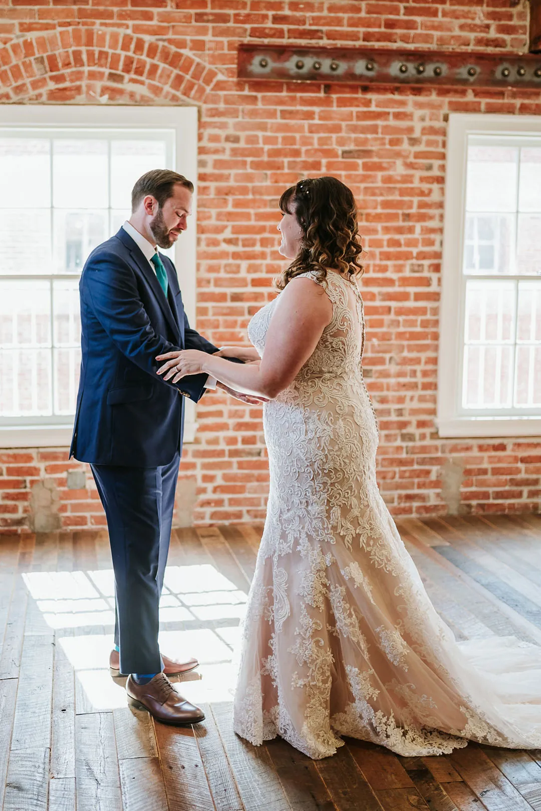 Couple hold hands in a bright loft room.