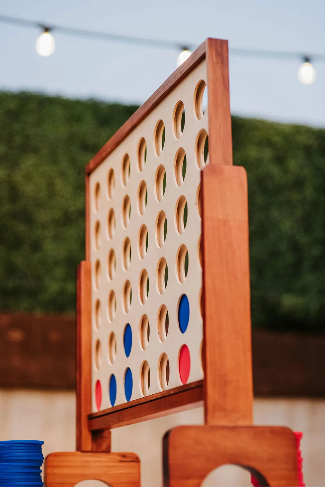 Oversized wooden Connect Four game on an outdoor terrace.