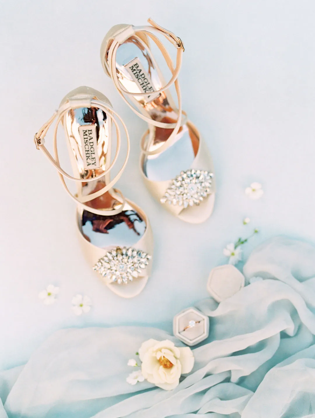 Sparkling bridal shoes arranged on pale fabric