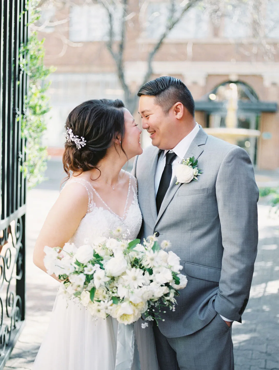 Bride and groom touching foreheads outdoors