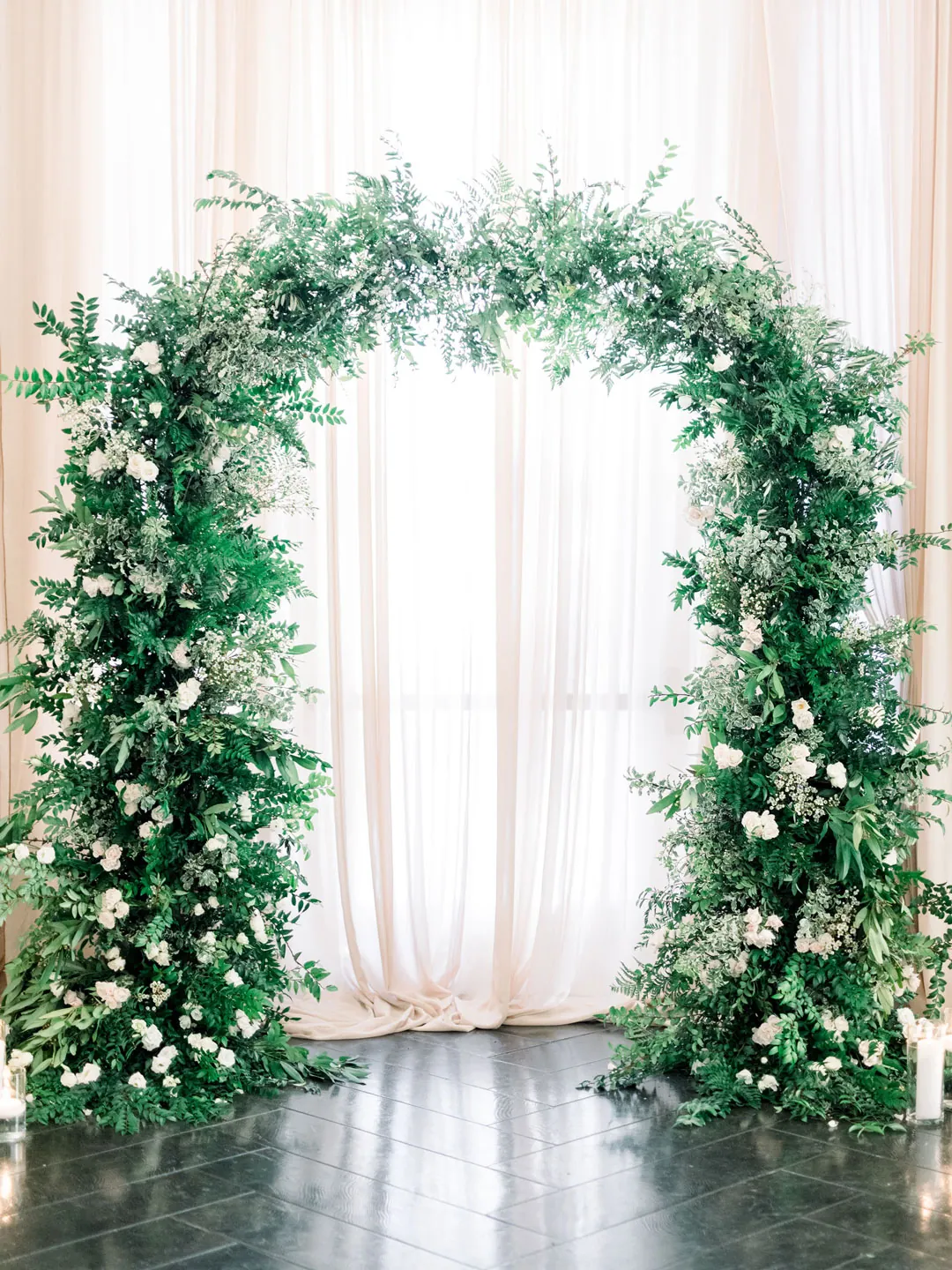 Circular greenery arch before a curtained window