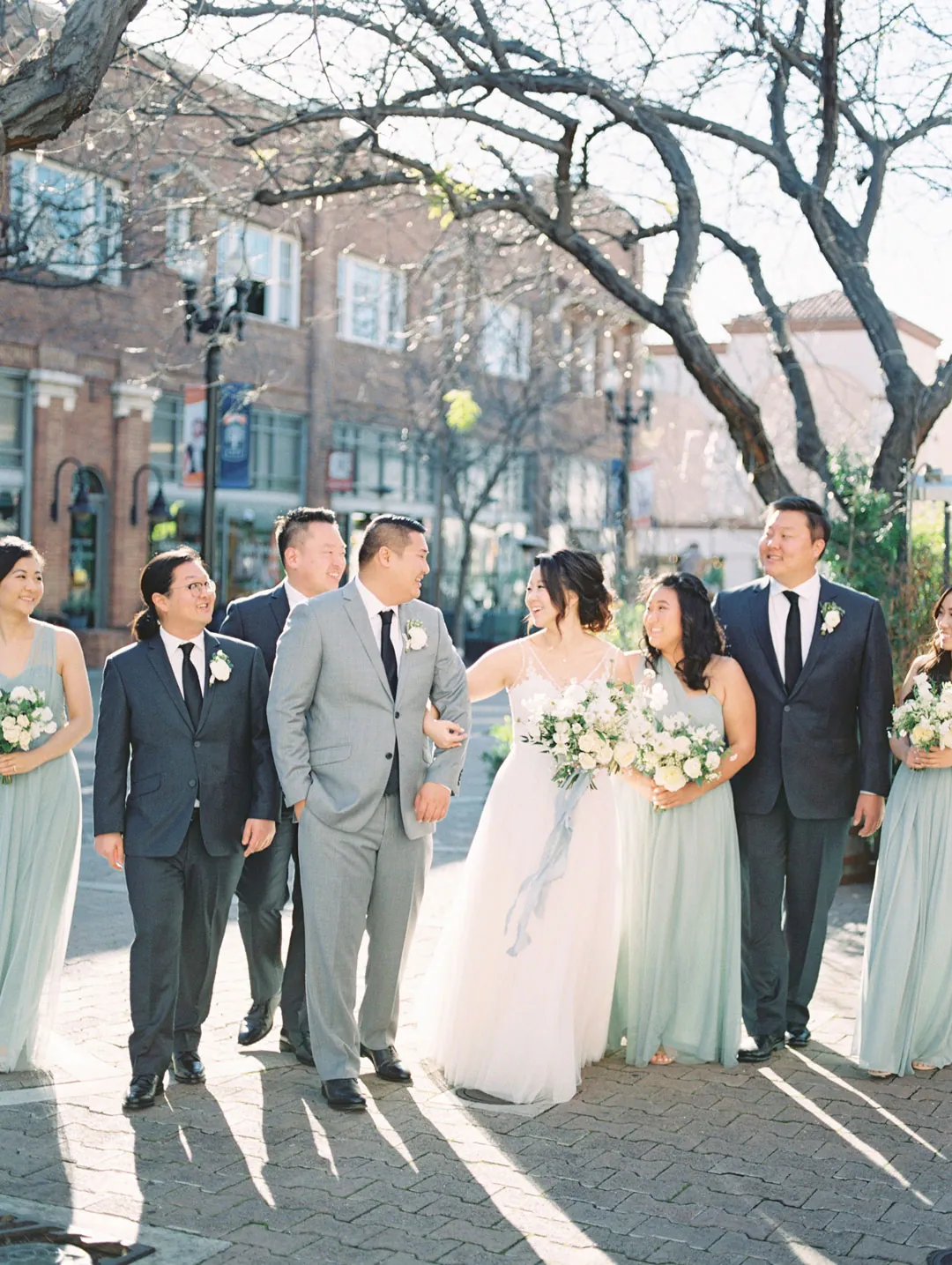 Wedding party walking down a city sidewalk