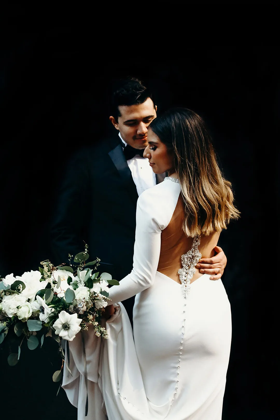 Couple embracing against a dark background