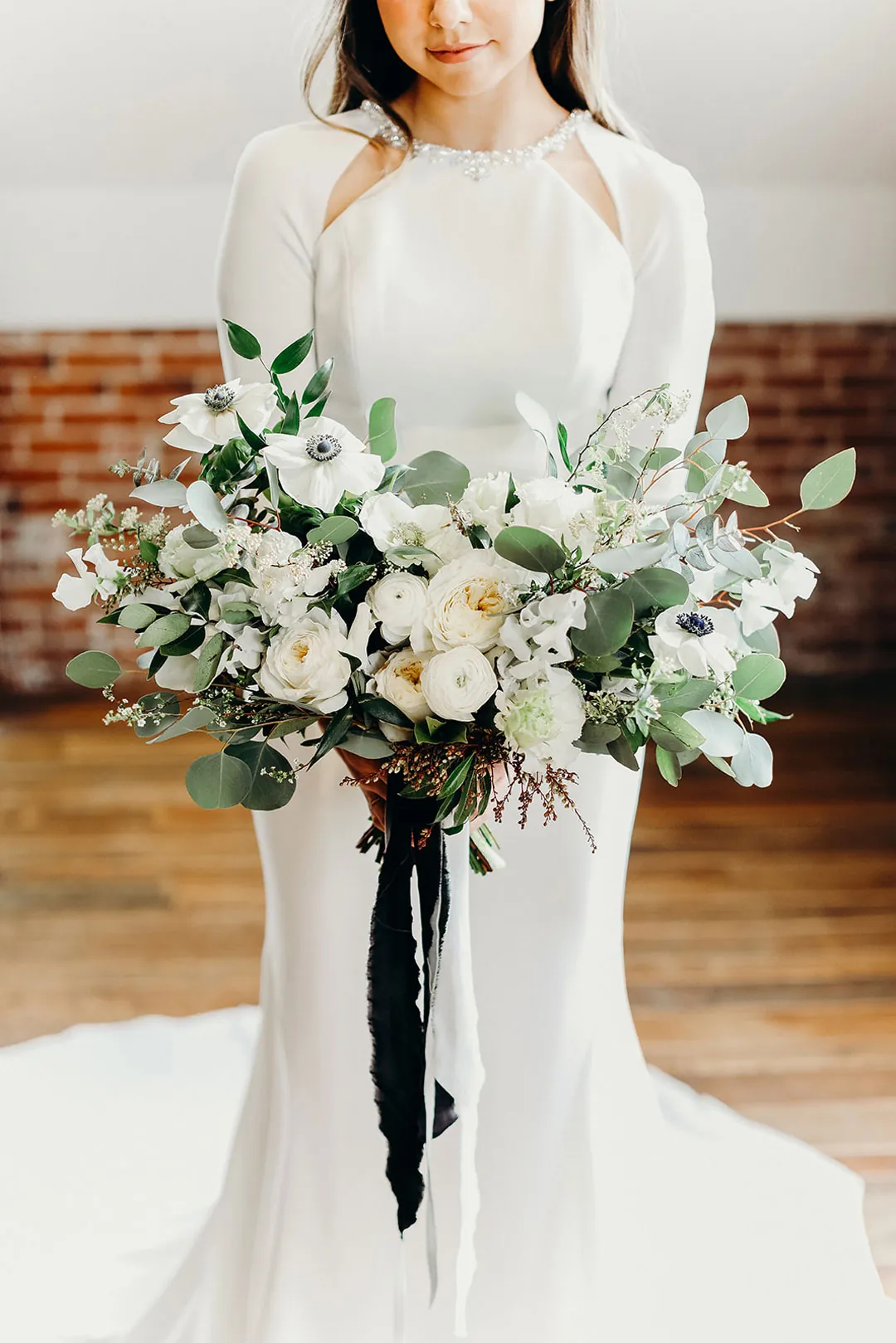 Bride holding a white and green bouquet