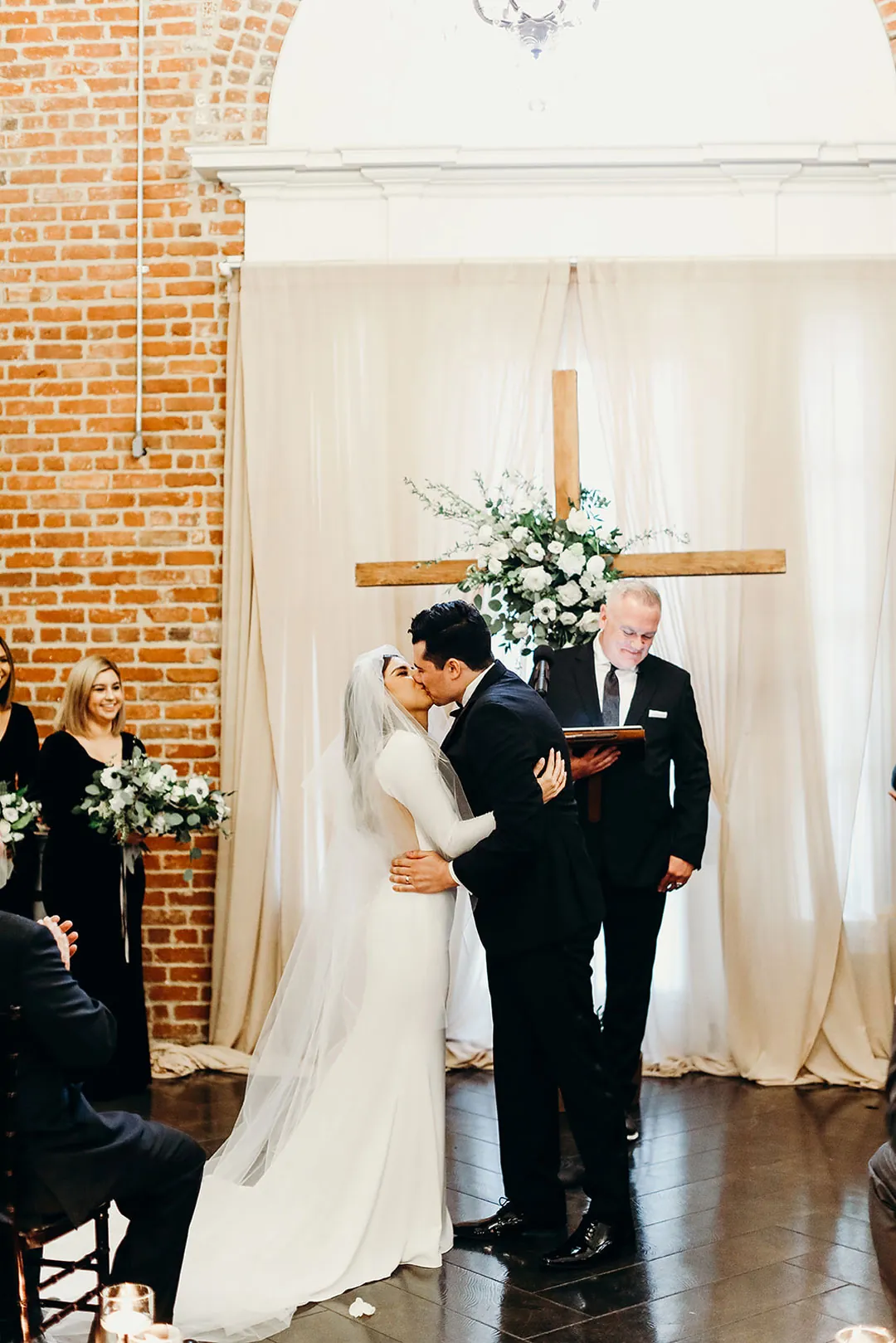 Couple exchanging vows beside a floral arrangement