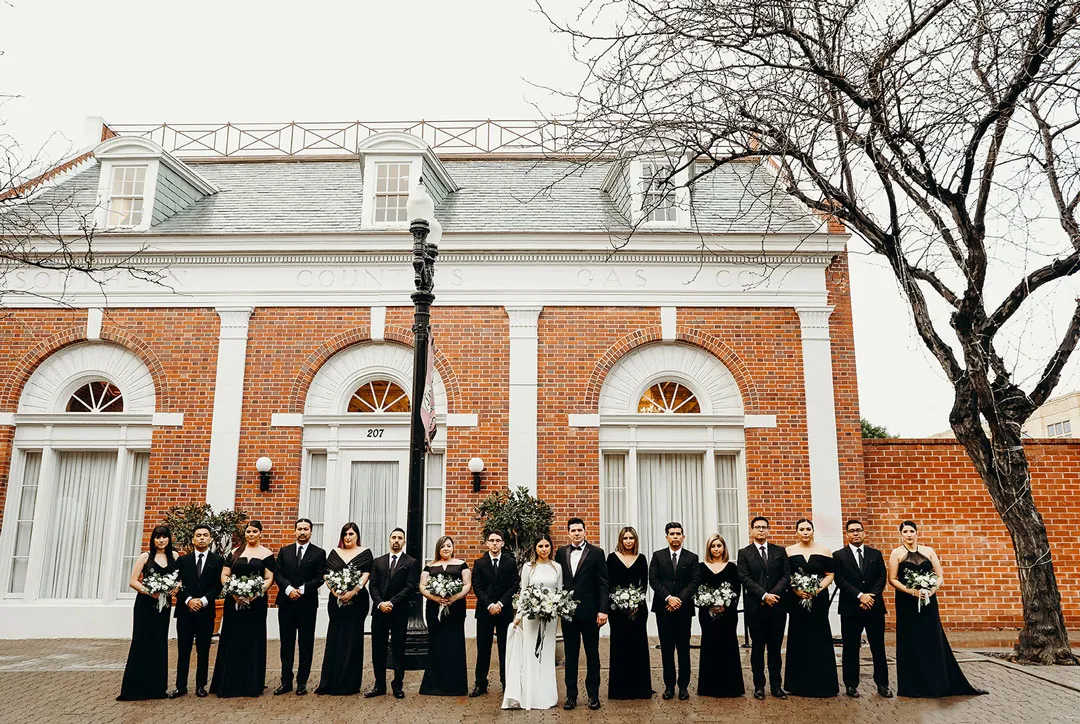Wedding party lined up outside a brick building