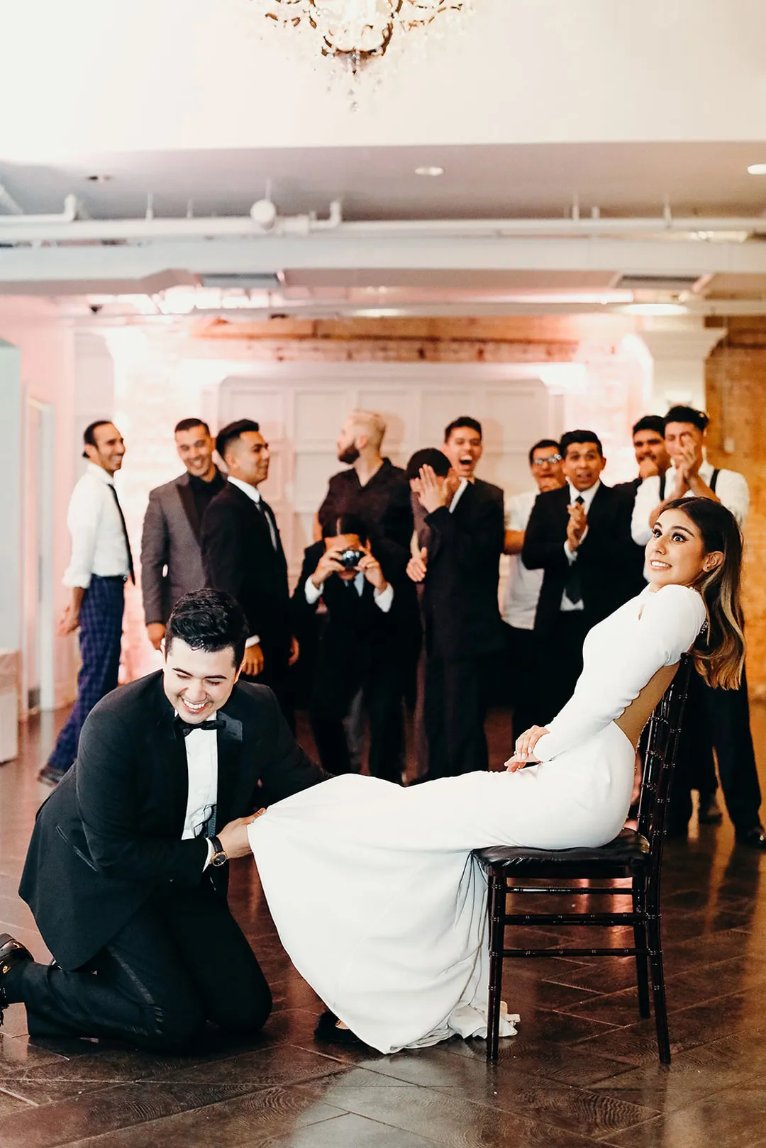 Guests watching the seated bride and kneeling groom