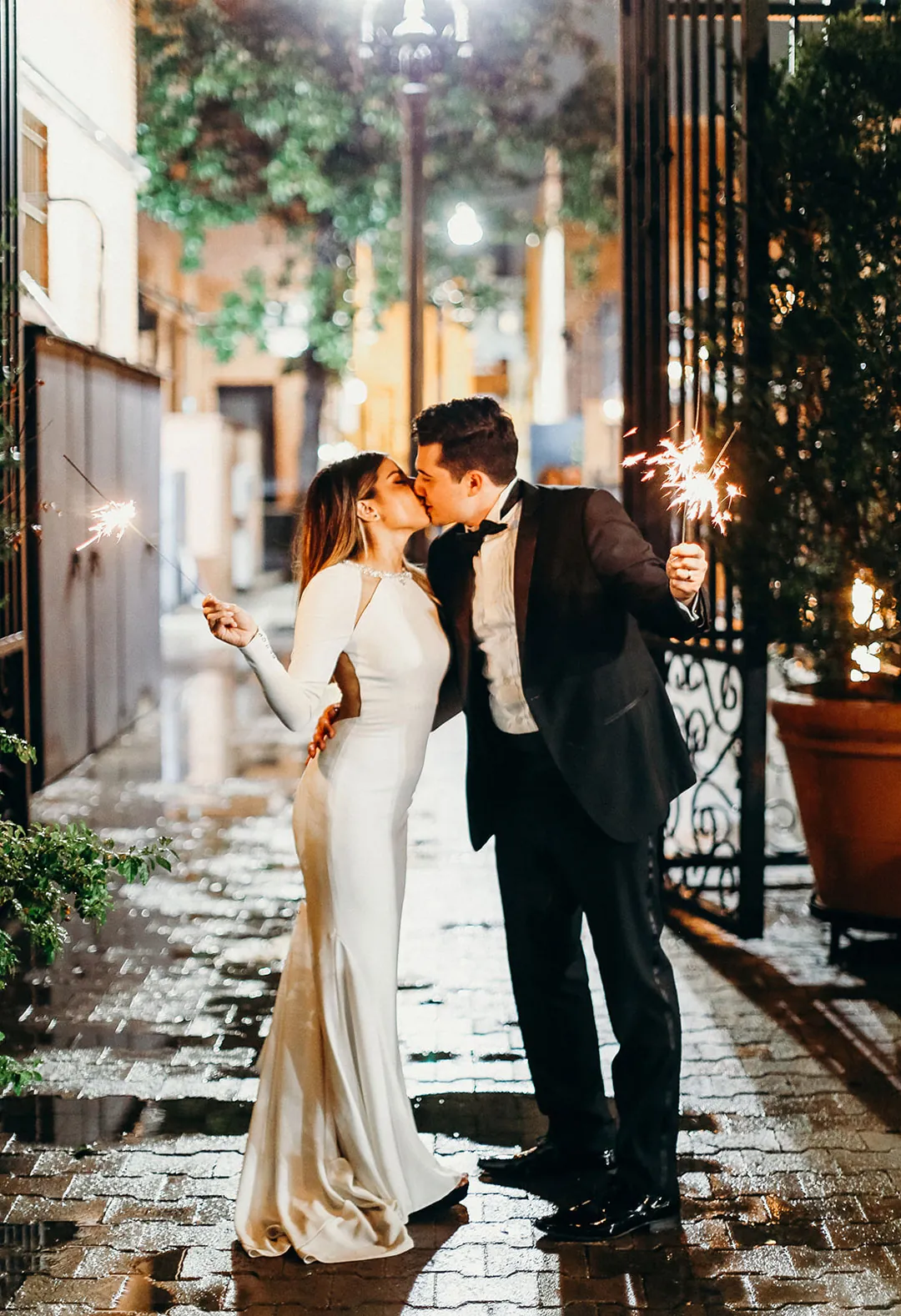 Couple standing together on a wet city sidewalk at night