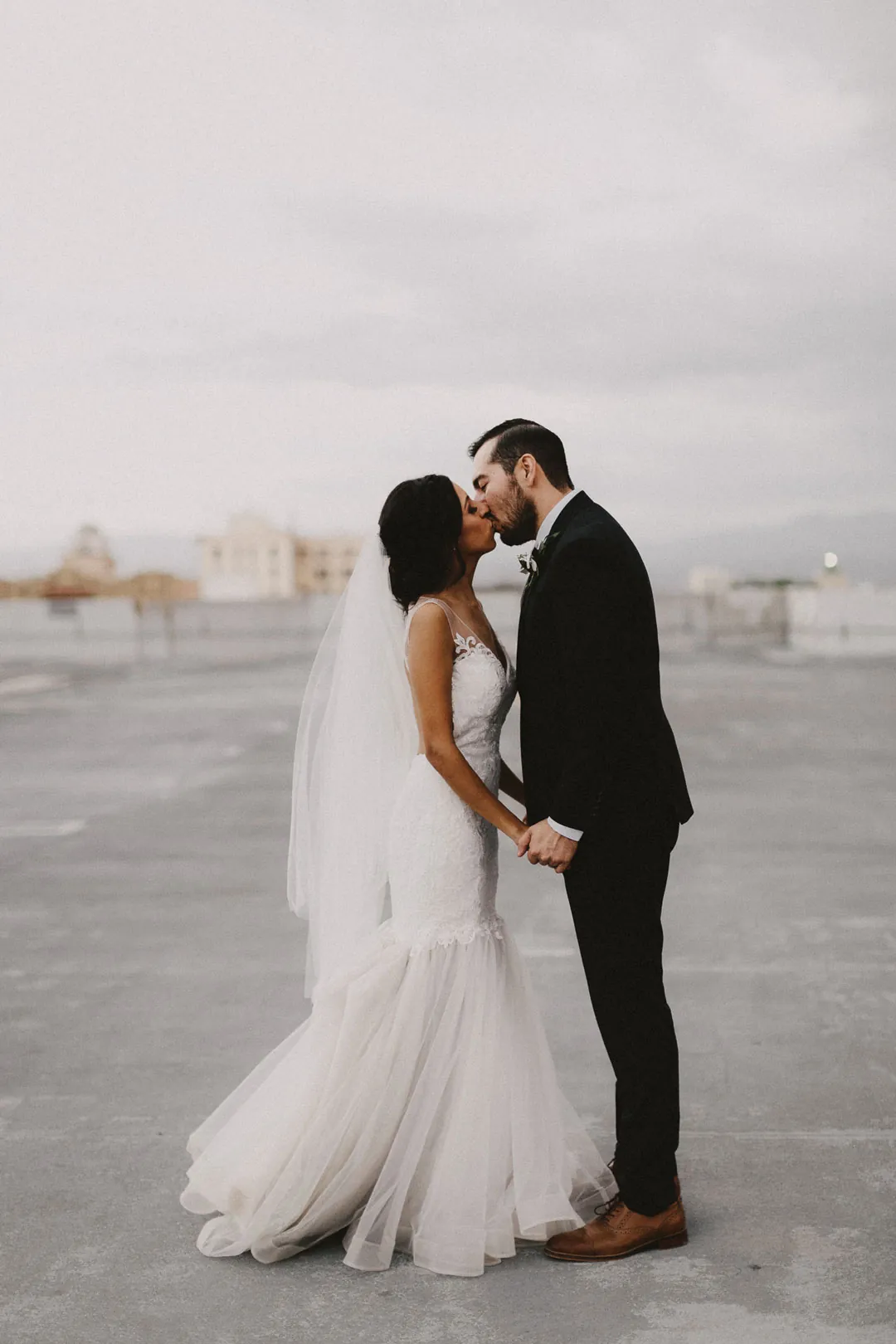 Bride and groom kissing on a rooftop