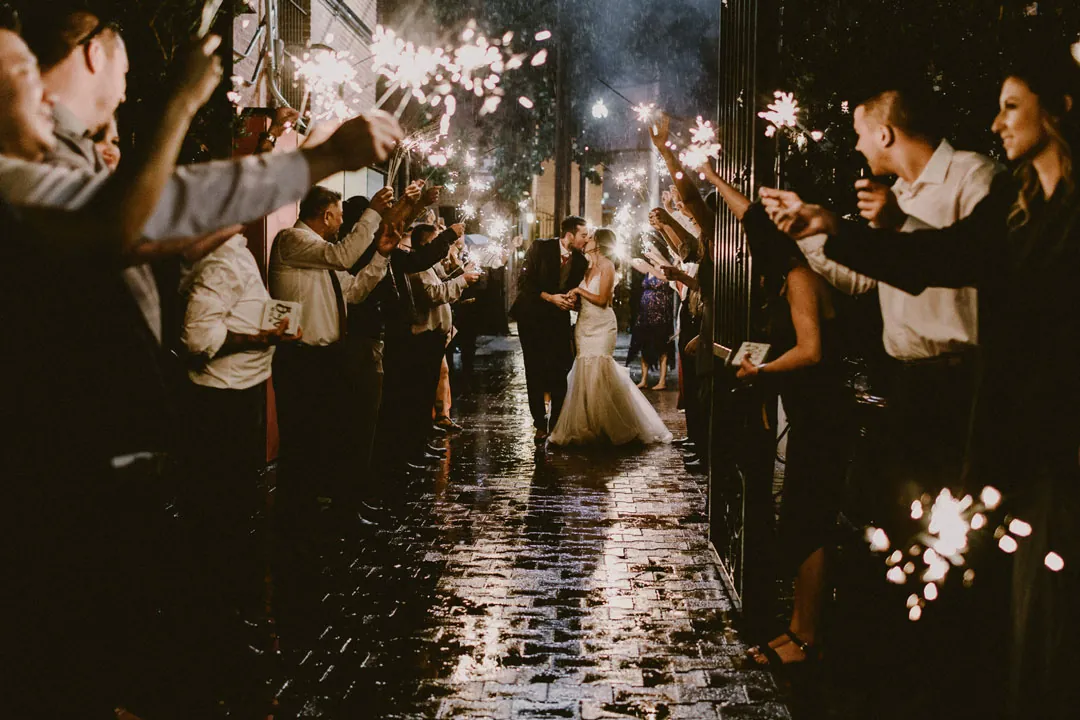 Newlyweds walking through a sparkler-lined exit