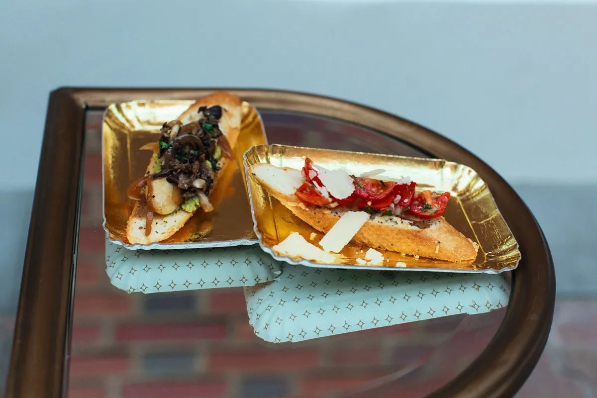 Small plates of savory food on a mirrored serving tray