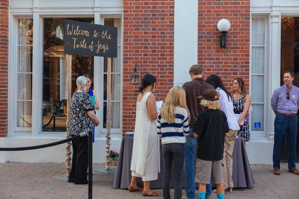 Guests waiting beside a welcome sign at an event entrance