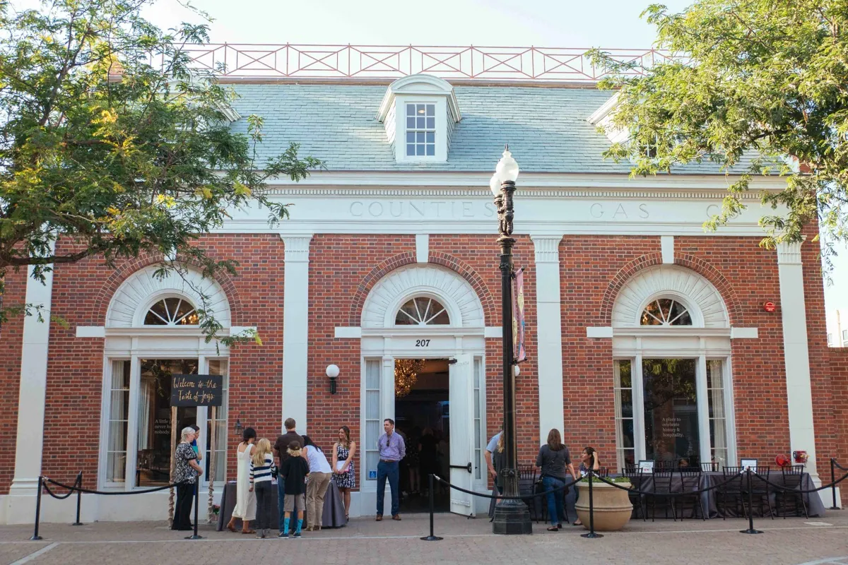 Guests gathering outside a brick building with arched windows