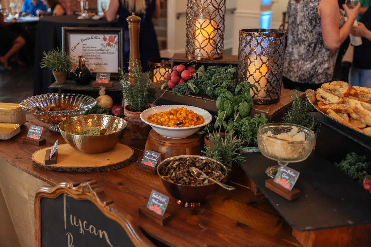 Buffet with vegetables, bread, sauces, and serving bowls