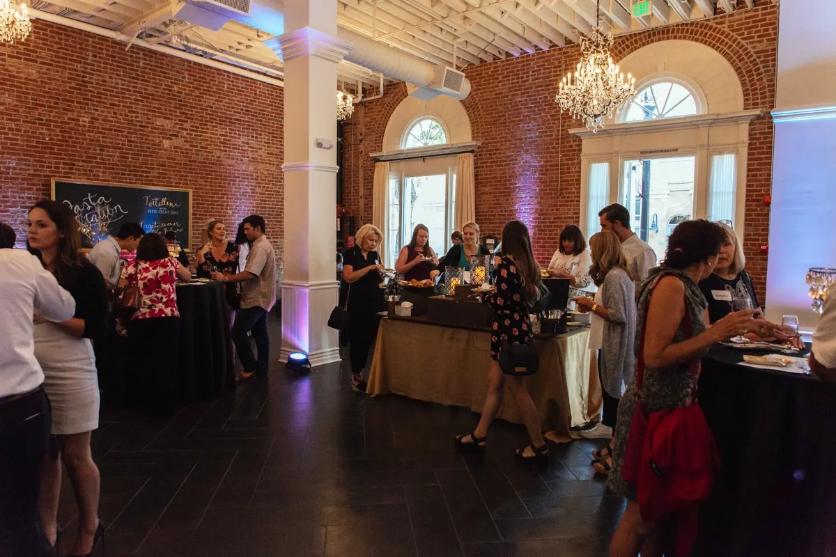 Guests gathering for a reception in a brick-walled room