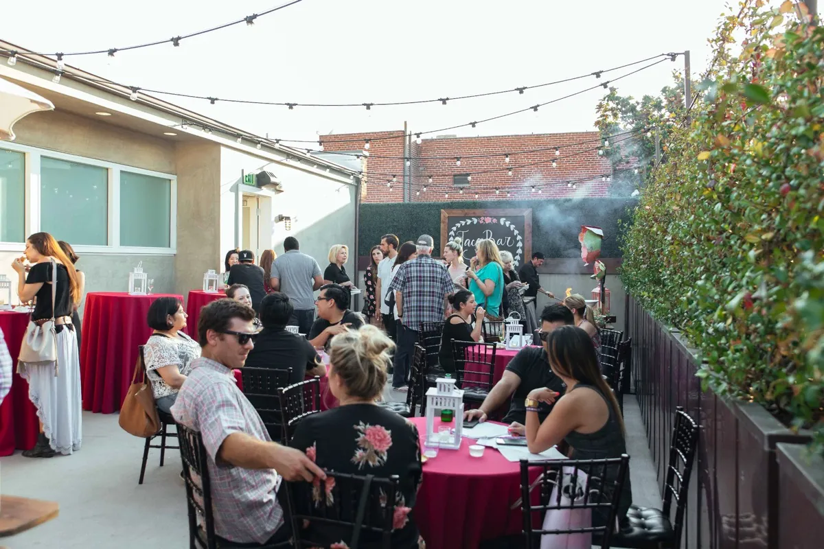 Guests dining outdoors beneath string lights