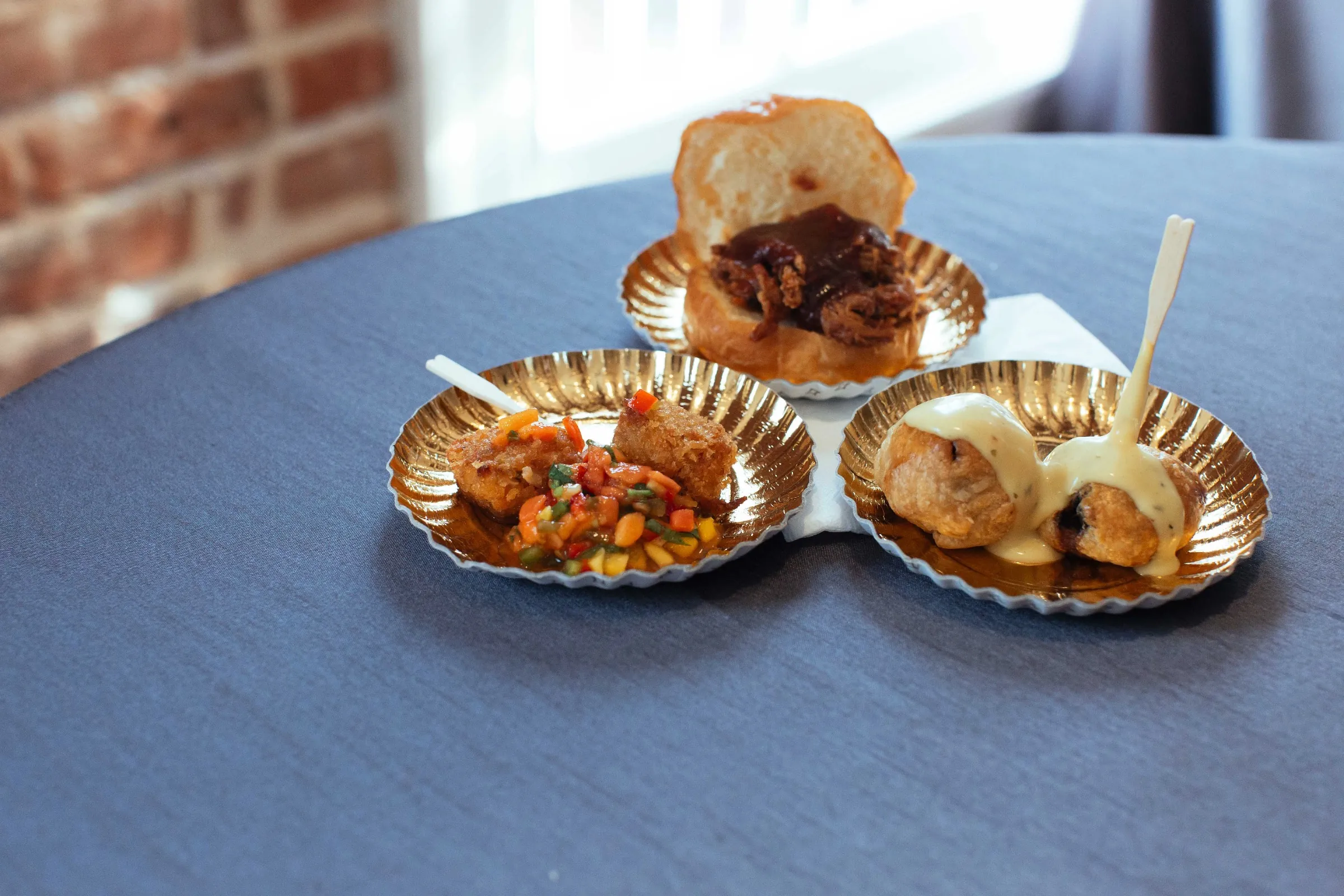 Small plates of meat, vegetables, and bread rolls