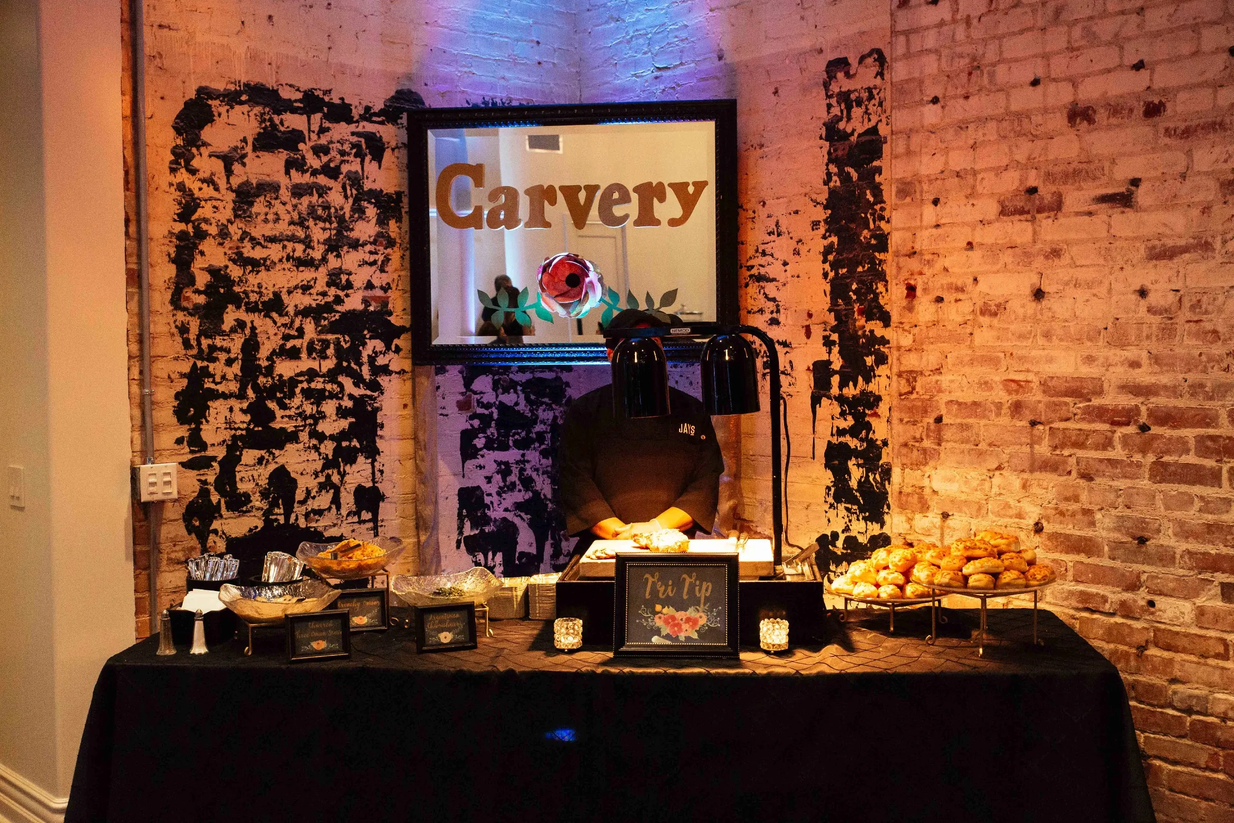 Carving station against a brick wall with decorative lights
