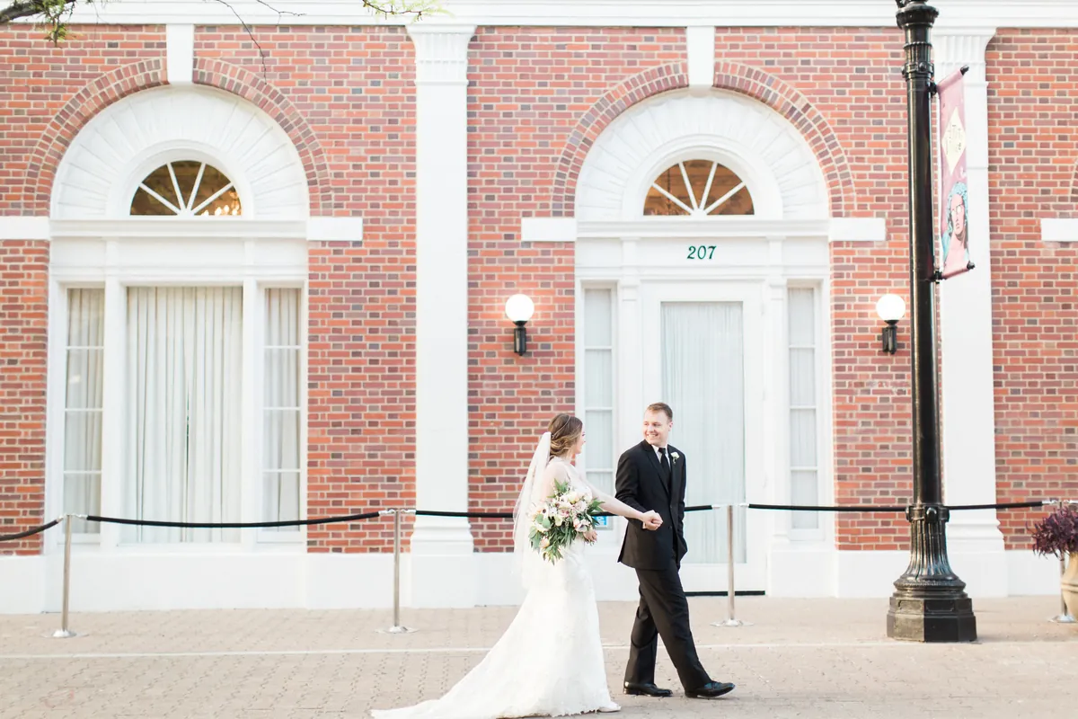 Couple walking outside a brick facade