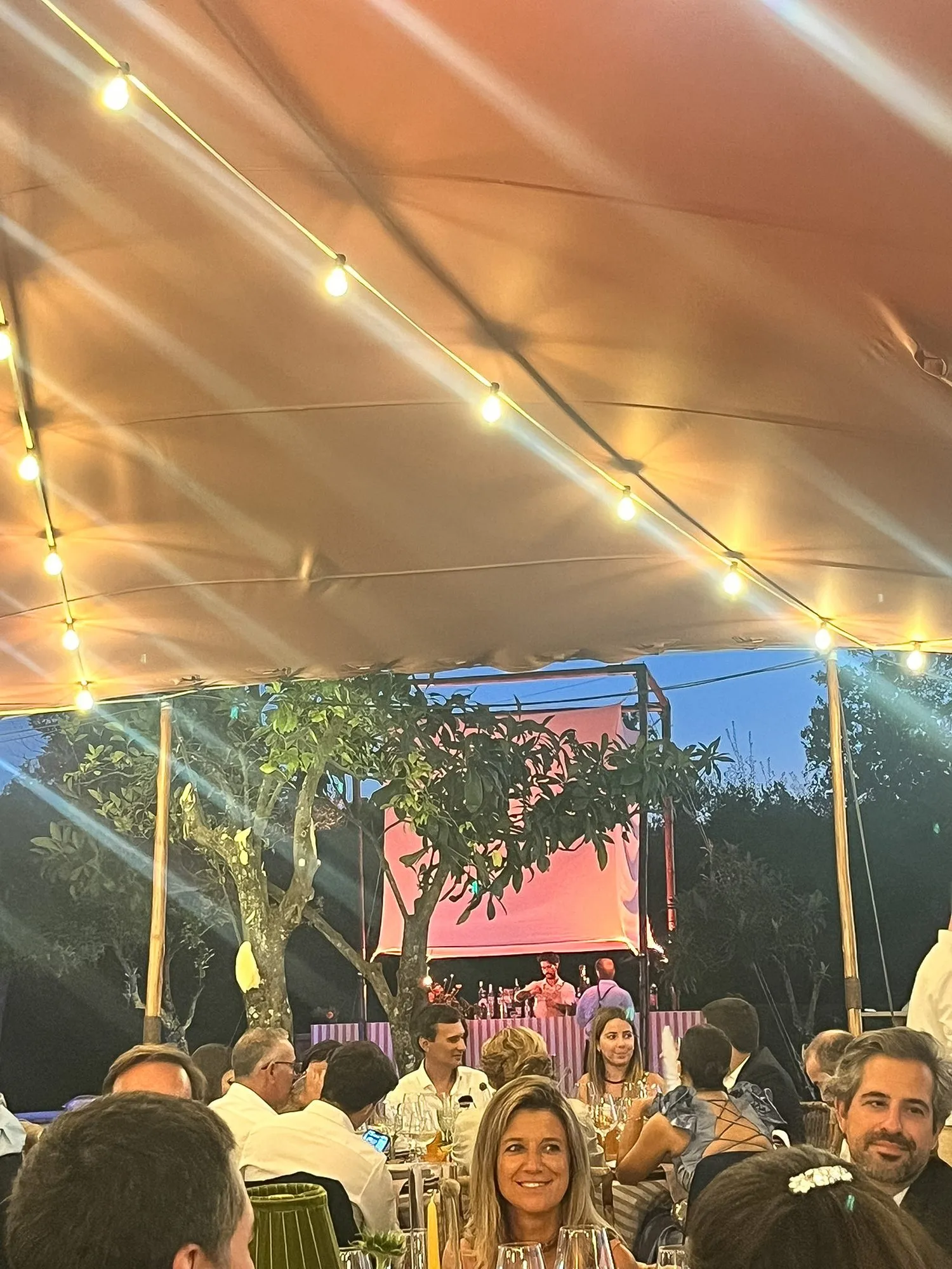 Luminária iluminada sobre o bar, vista de um jantar sob uma tenda Beduína