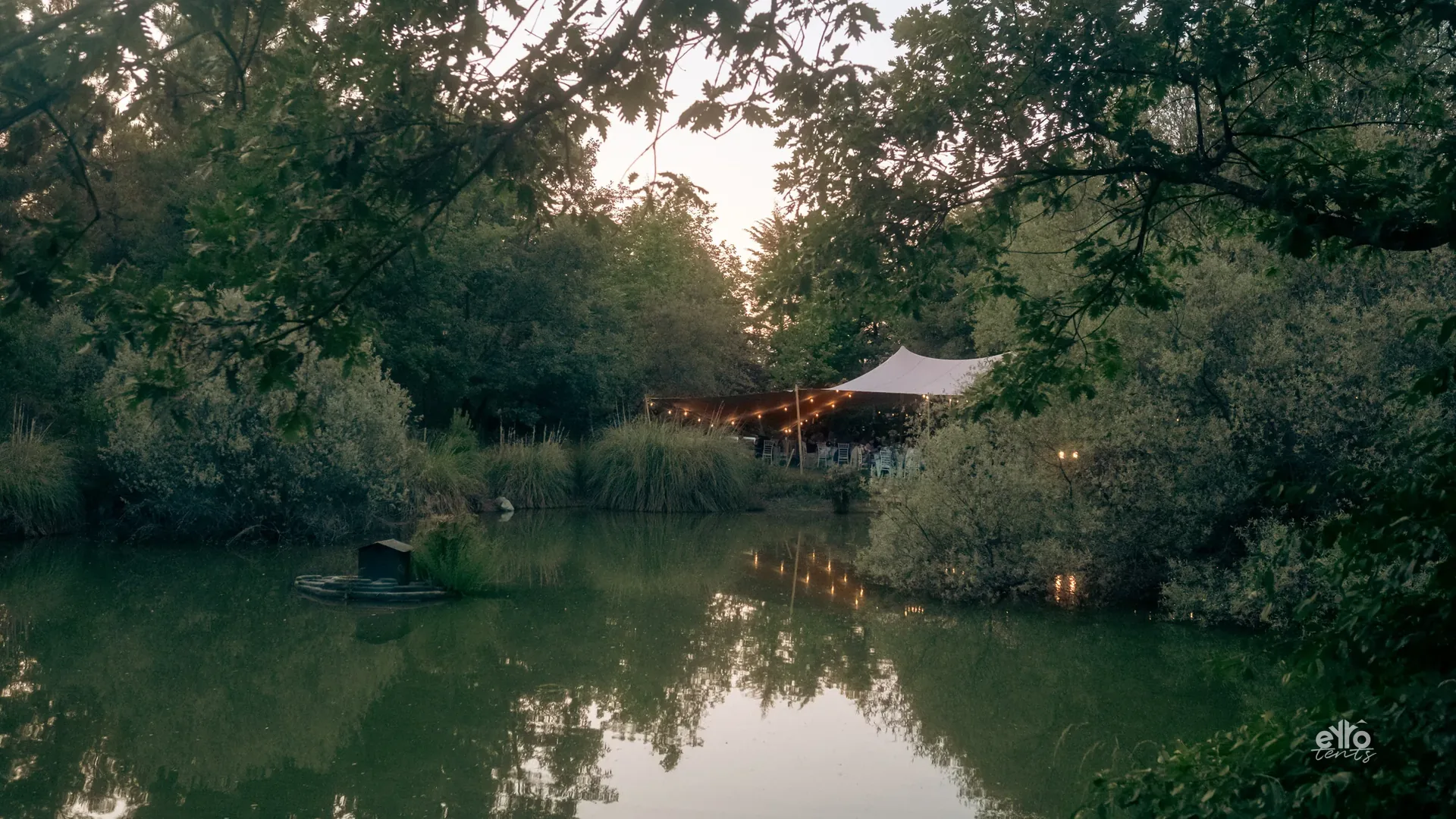 Festoon lighting by a lake at dusk