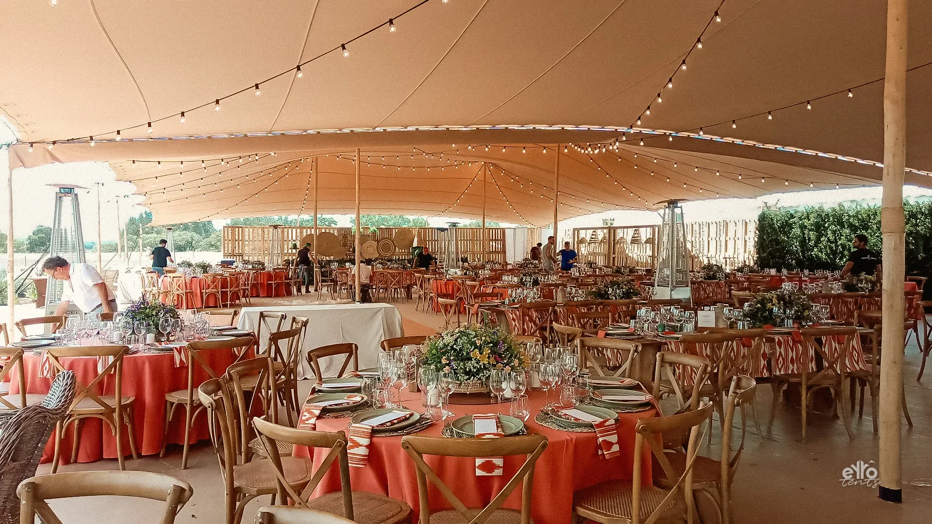 Wedding banquet with round tables under a large stretch tent