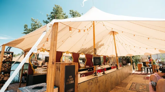 Inside a sailcloth tent set for dinner
