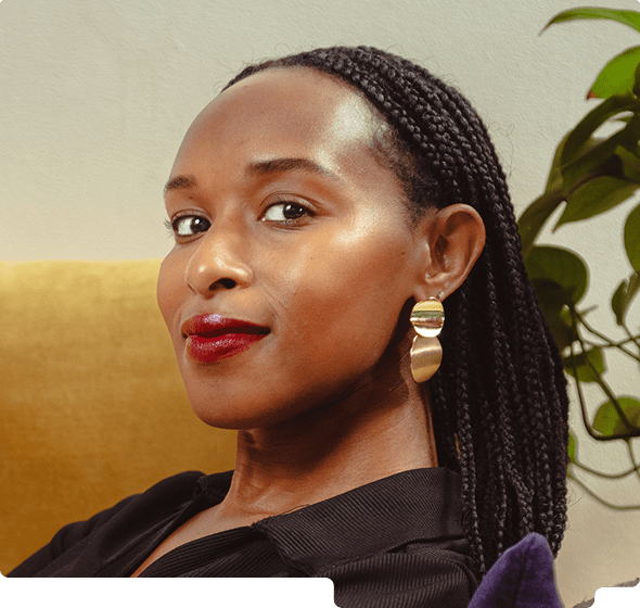Portrait of a woman with braided hair, wearing gold earrings and red lipstick, sitting against a yellow and green background.