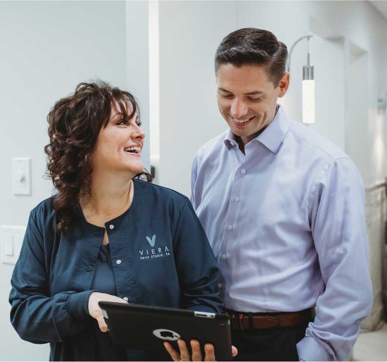 Photo of a team member and a patient looking at an iPad