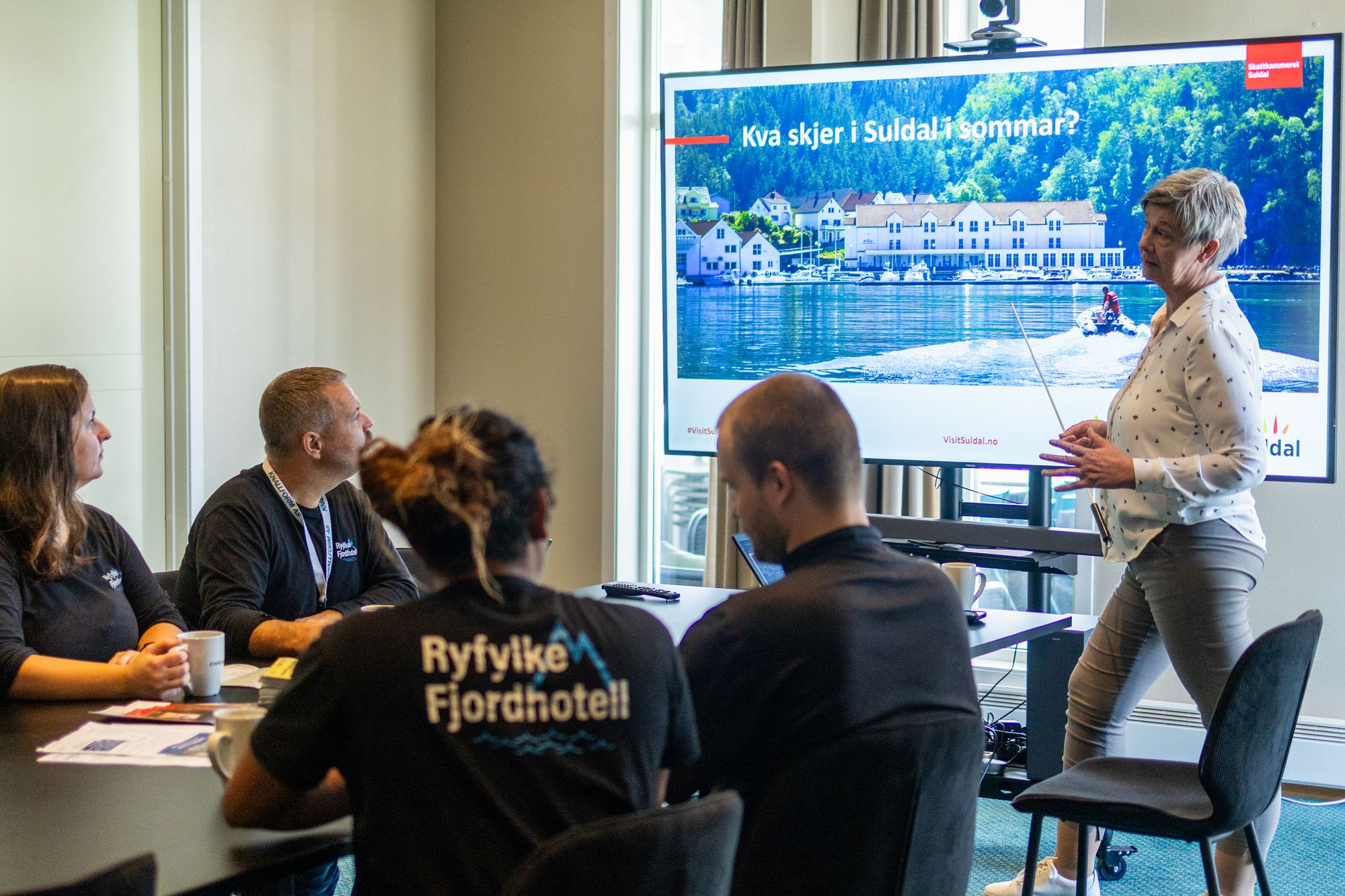 Bilde av møterom der person held presentasjon