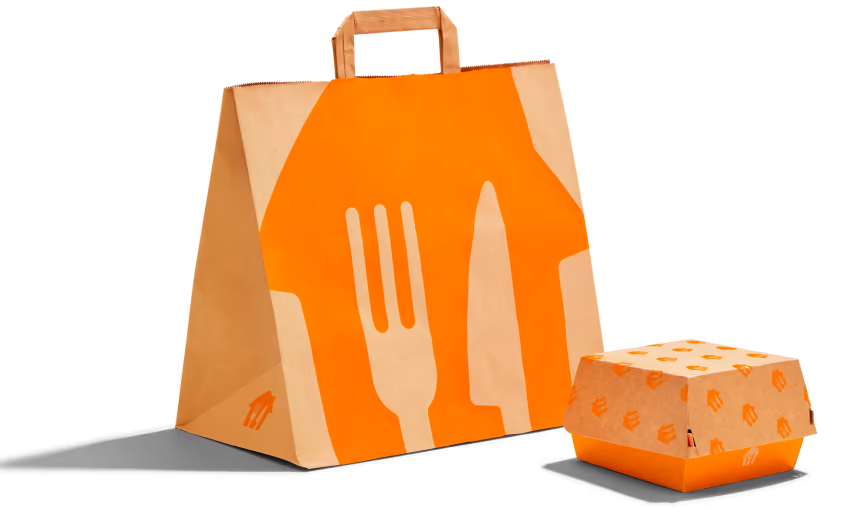 Brown paper takeout bag and burger box with orange fork and knife graphics.