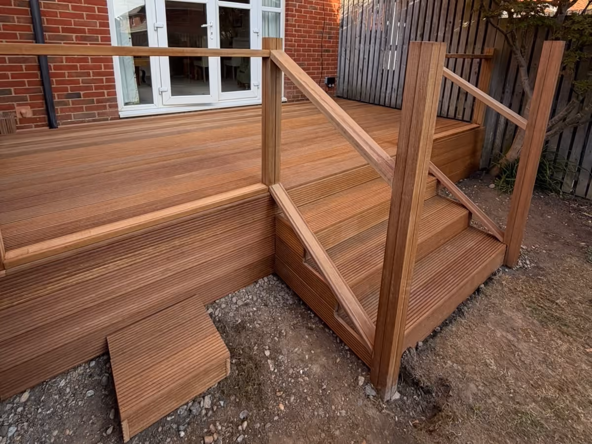 Close view of completed hardwood decking steps with wooden handrails and grooved deck boards
