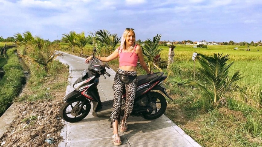 An expat woman posing with her motorbike in Bali