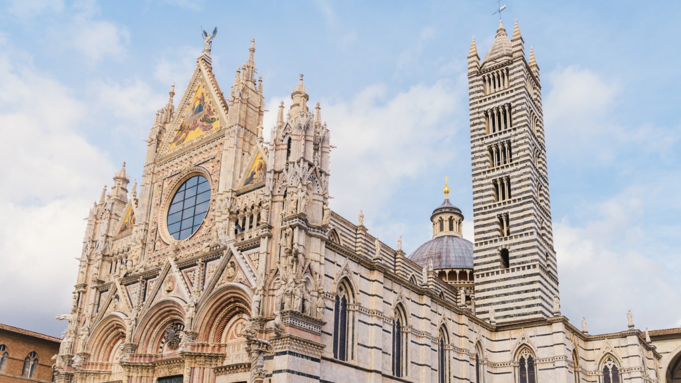 The Duomo di Siena, a white and black Cathedral, on a clear day