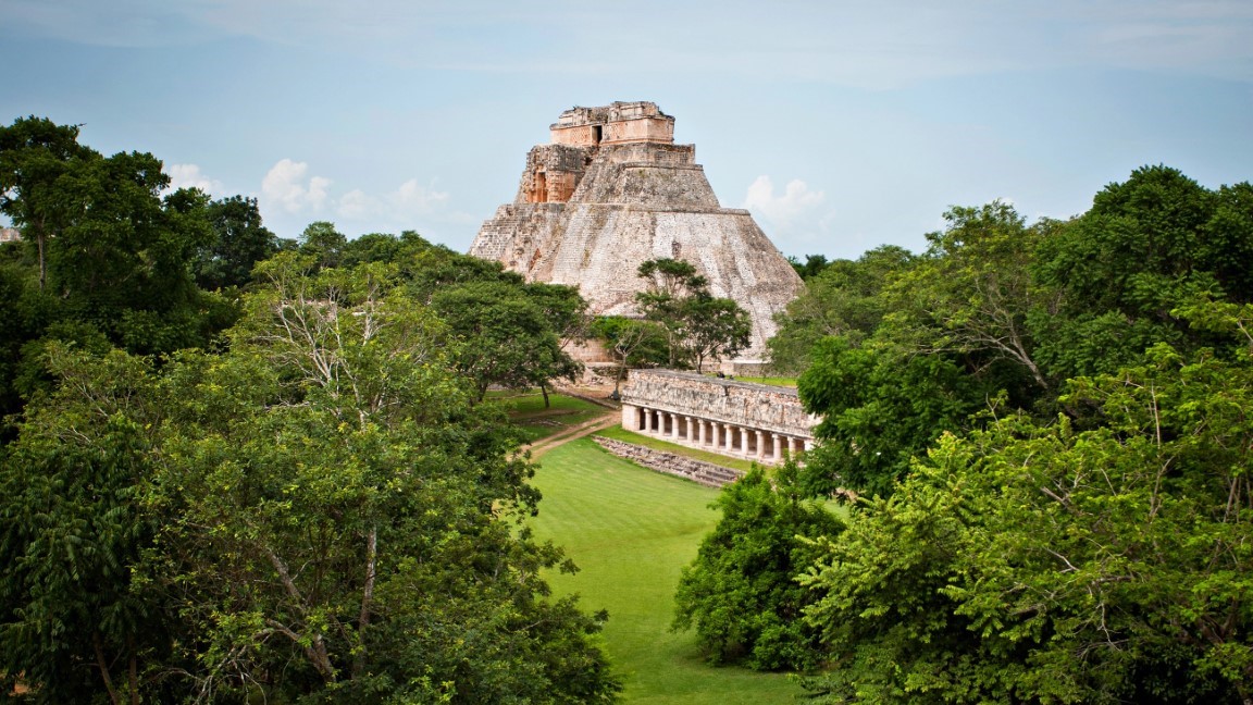 A view of Mayan Ruins in the middle of a lush jungle in the Yucatan Peninsula