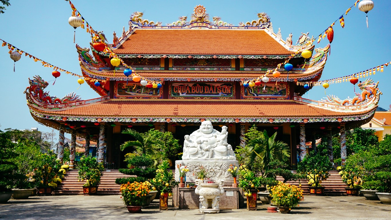 A very bright temple with a fat happy Buddha statue in the middle