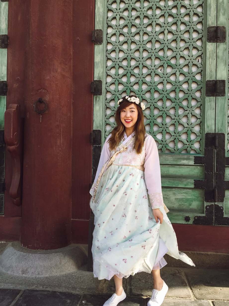 A foreigner living in Seoul having fun wearing the tranditional hanbok dress at a temple