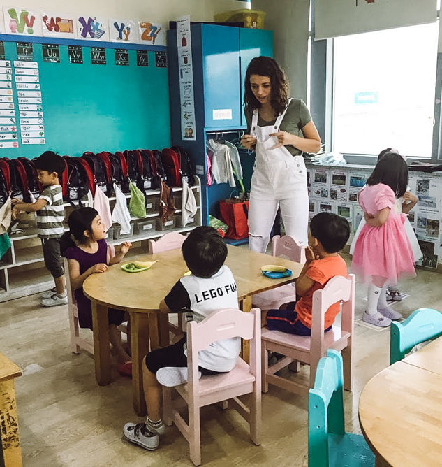 An English teacher in Seoul, Korea in her classroom interacting with her young students