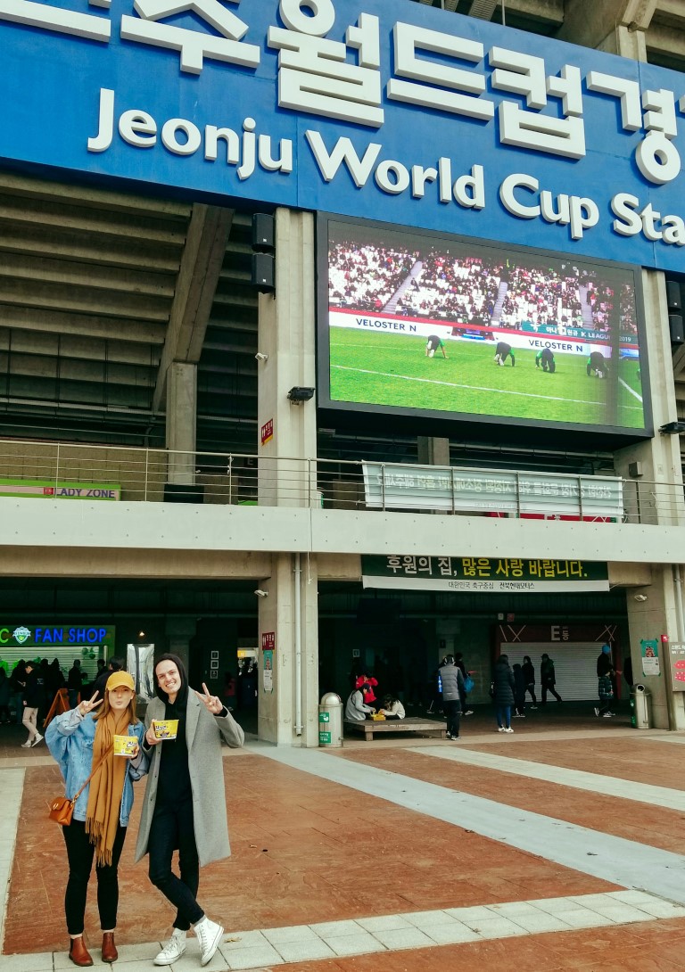 A couple standing in front of the Jeonju World Cup Stadium