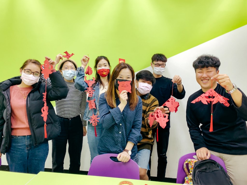 a group of students studying Chinese in Taipei holding up their Lunar New Year decorations