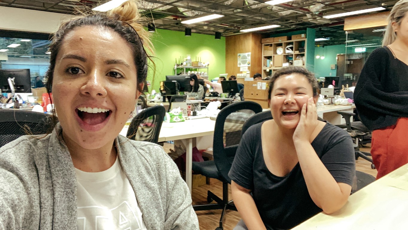 two coworkers happily taking a selfie together in their office in taiwan