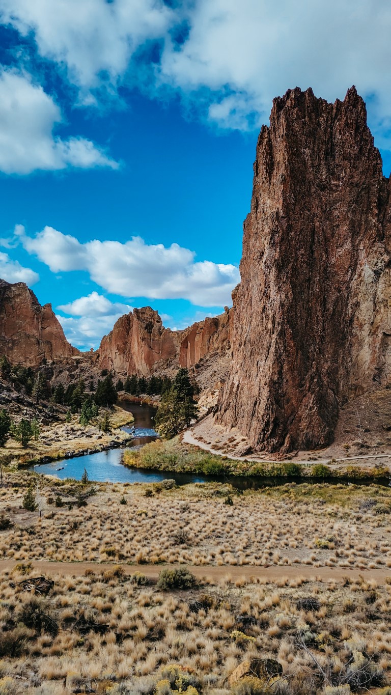 a view of a rocky mountain peak coming out of a valley and a river in Oregon