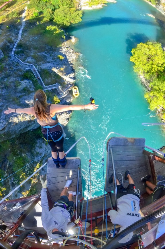 A girl about to jump off the platform to go bungee jumping over a lake in New Zealand